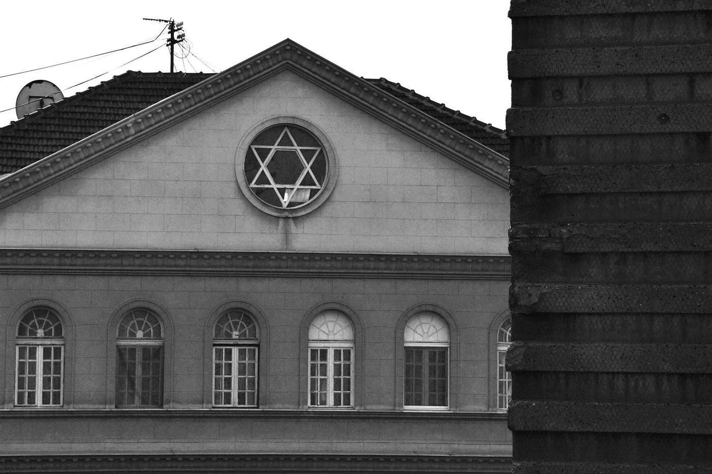 Black-and-white view of the Belgrade synagogue facade with a Star of David in the circular window above the entrance.
